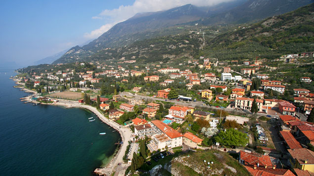 Malcesine. A Baldo hegyre vezető felvonó a nagy fehér épületből indul. 11 óránál a hegyen kivehető a középső állomás is.